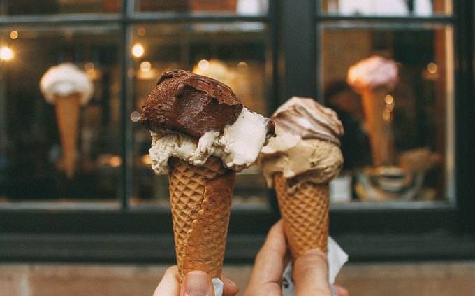 Two hands holding two ice cream cones