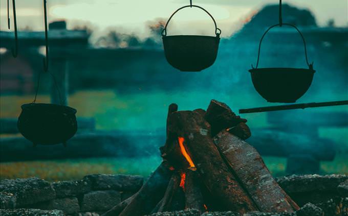 pots hanging over campfire