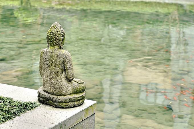 Buddha statue by pond