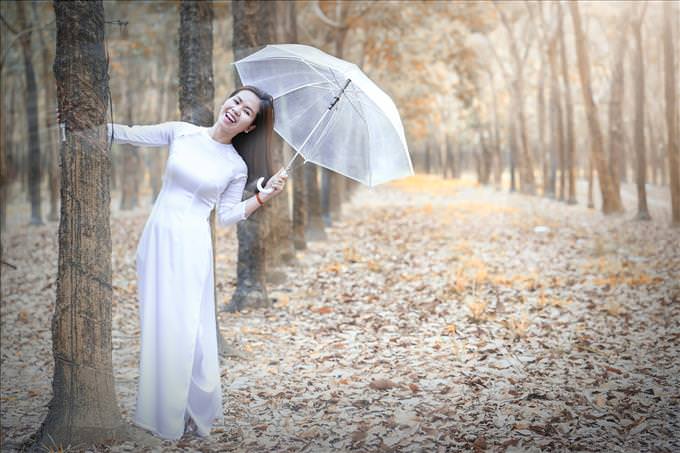 Asian woman with umbrella in forest