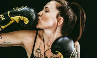 woman kissing boxing gloves