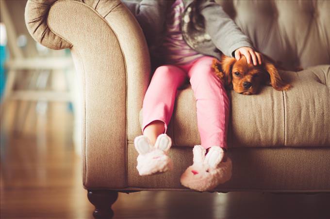 little girl and puppy on couch