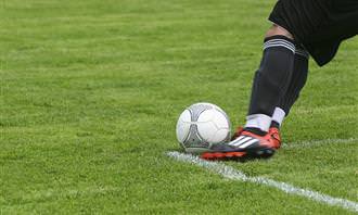 a soccer player's foot kicking a ball