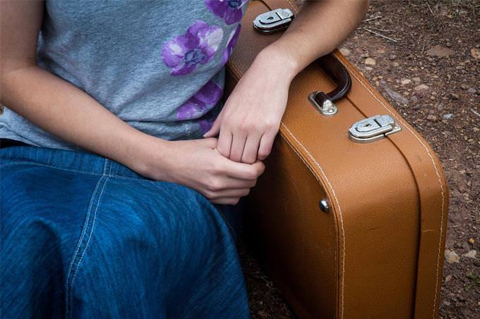 A woman leaning on a suitcase