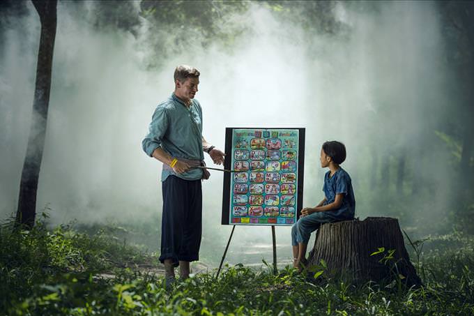 man teaching boy in forest