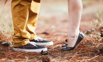 A woman's feet tiptoeing next to the feet of a man