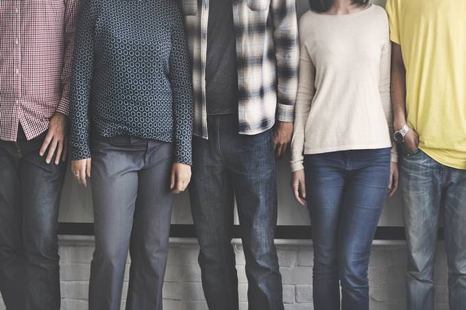 A group of people leaning against a wall