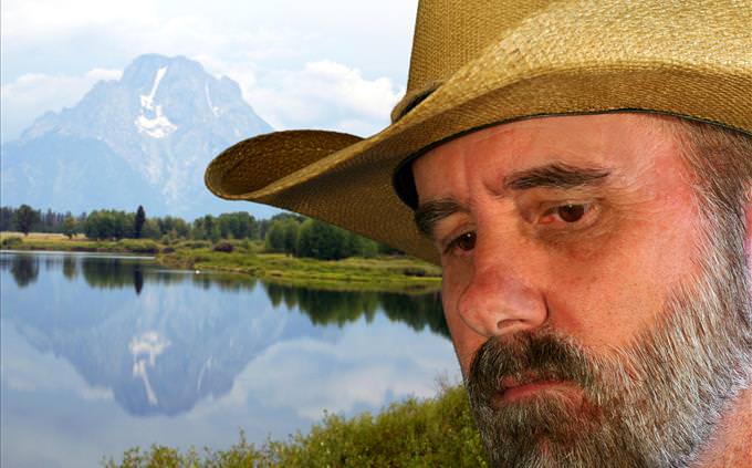sad cowboy in front of mountain