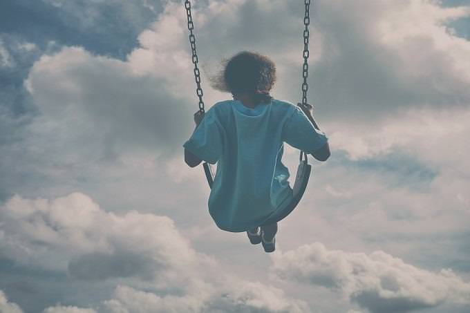 a girl swinging in the sky