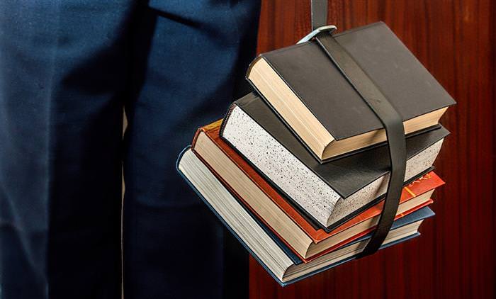 mental strength: man holding books with a belt