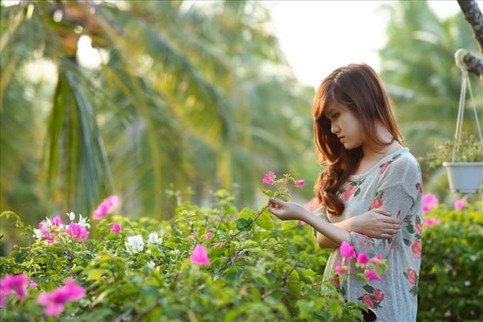 sad woman picking flowers