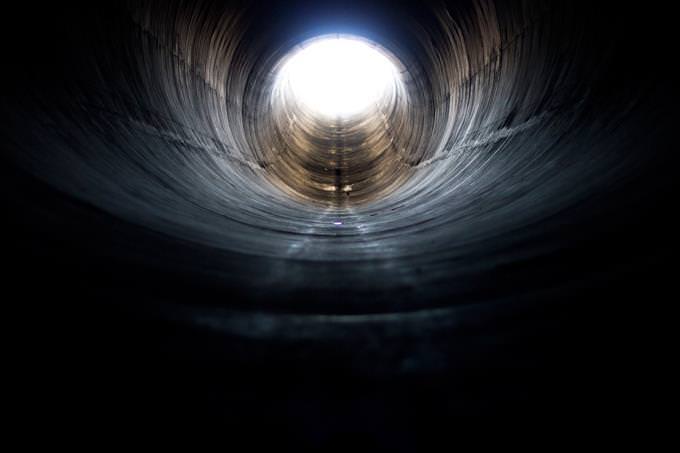 A tunnel leading to an exit with light