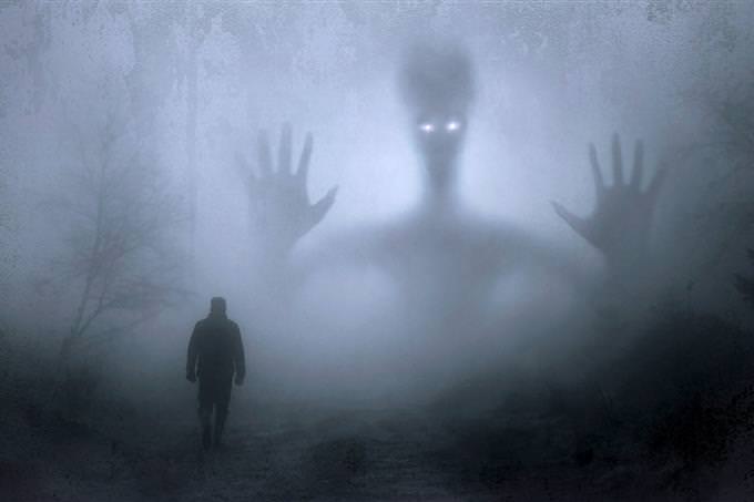 a man walking into fog with a scary figure looming in the background