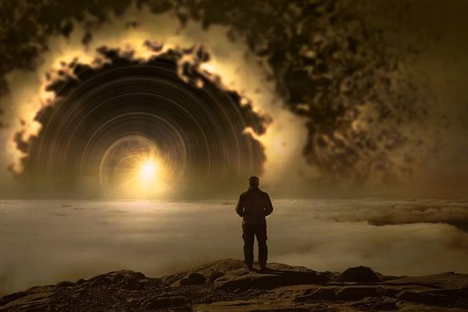 A man standing in front of a landscape that looks like a gateway to another world