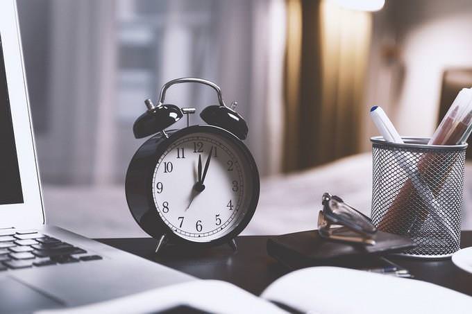 A clock placed next to a notebook