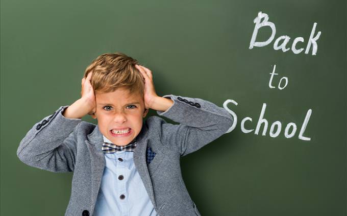 boy in font of 'Back to School' sign
