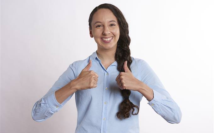 A smiling woman with two thumbs up