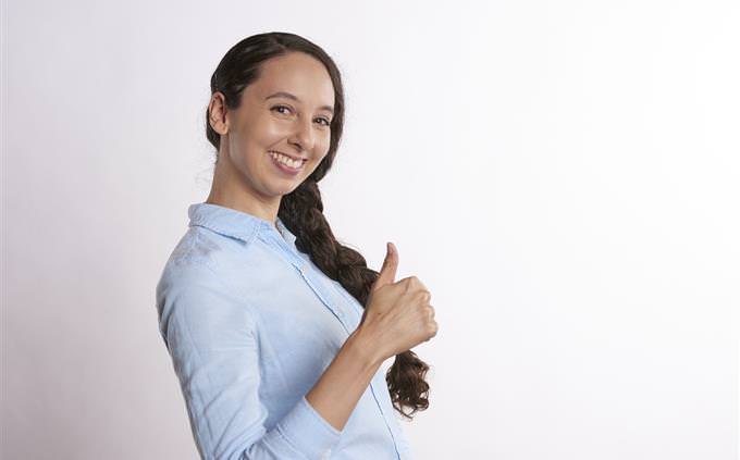 A smiling woman with a raised thumb