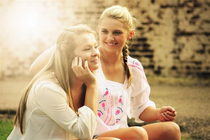 Two girls sitting and smiling