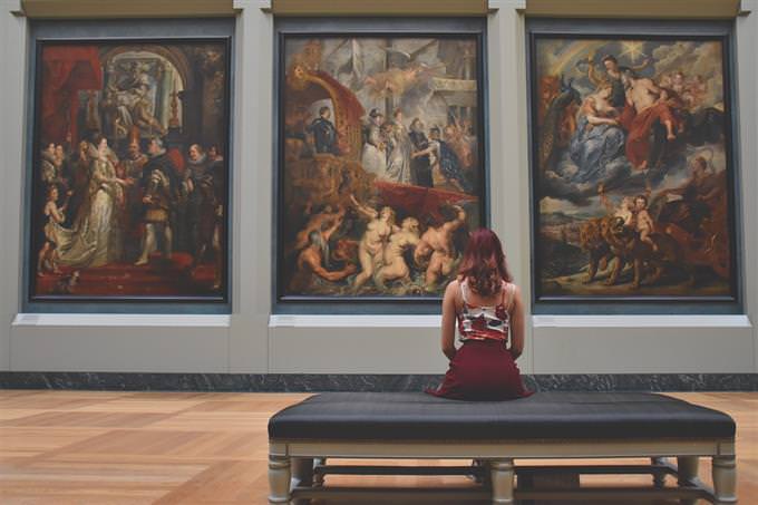 A woman looking at paintings in a museum