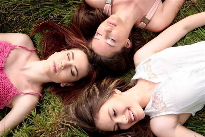 Women lying on grass head to head