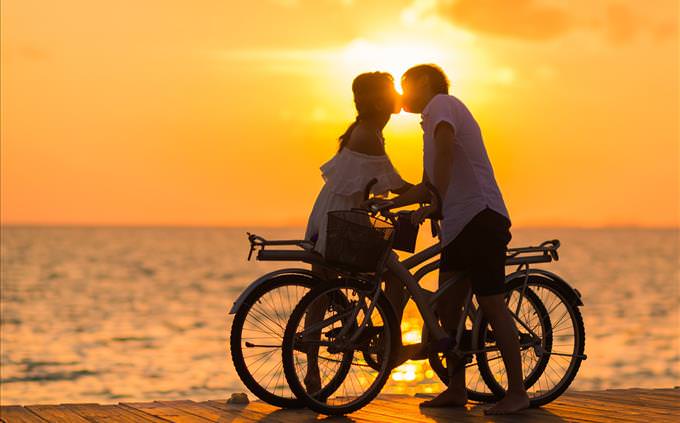 couple on bicycles kissing