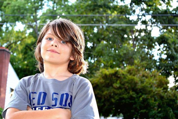 A mature child standing with their arms across their chest