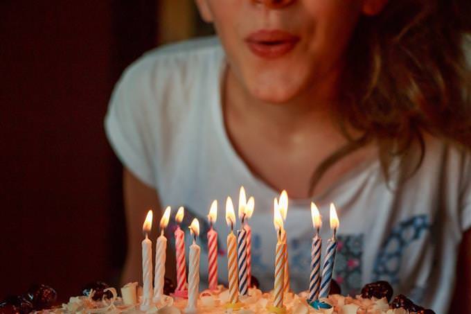 A woman blowing candles on a birthday cake