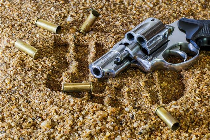 gun and bullets in sand