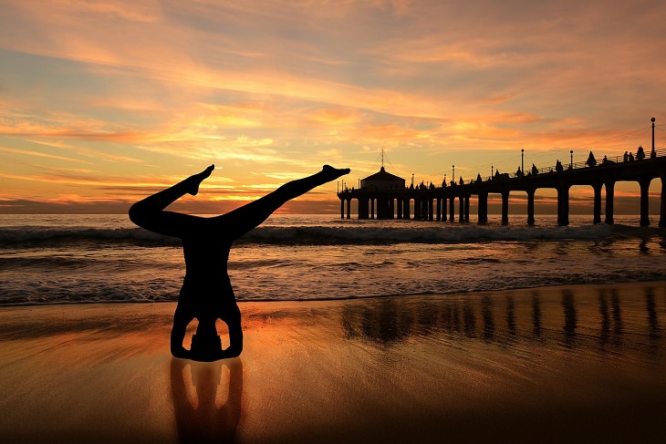 woman doing yoga on beach