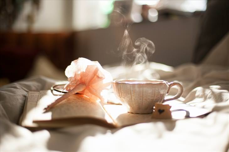 steaming cup of tea on a bed