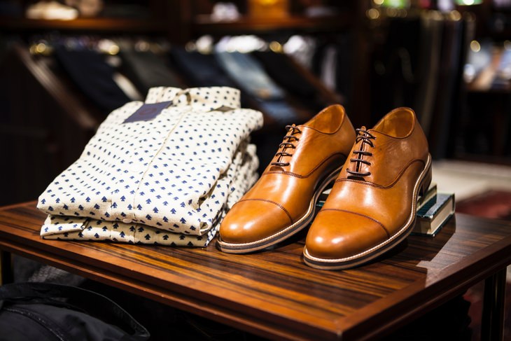 brown leather shoes next to a white pattern dress shirt