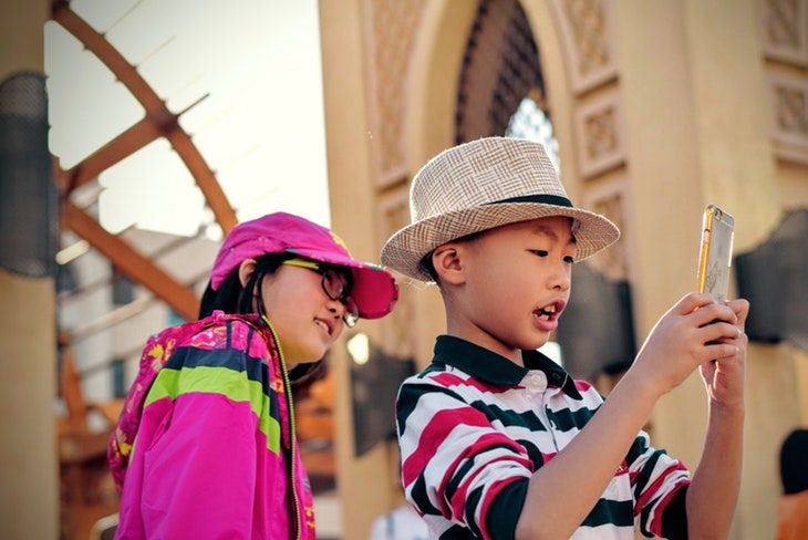 girld and boy taking a picture on the smartphone