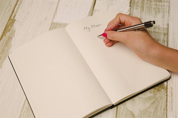 a hand writing in a notebook