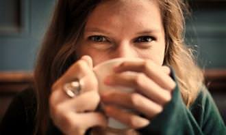 a woman sipping from a mug