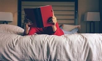 a man reading a book in bed