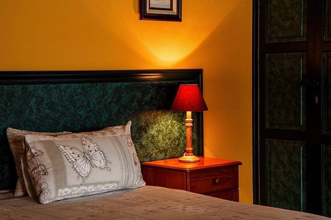 A bedside lamp lit beside a bed