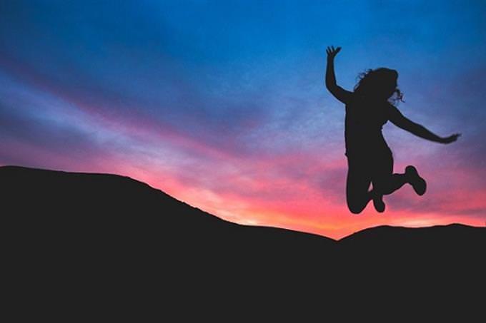 woman jumping in the air at dusk
