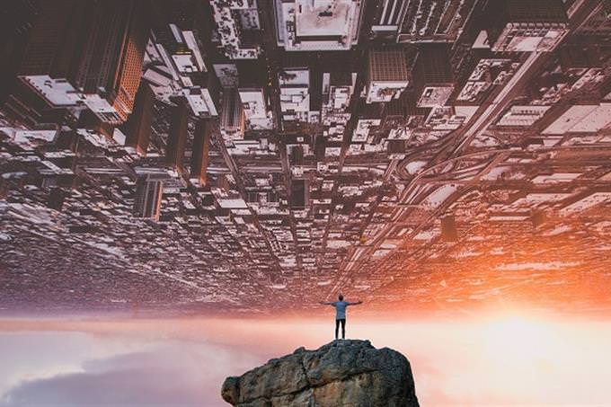 a man hovering over and upside-down city