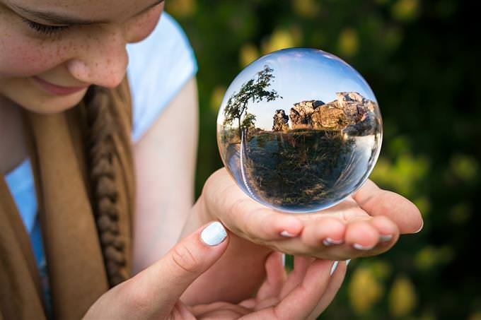 How your life flows: A girl looking at a landscape that appears inside a crystal ball