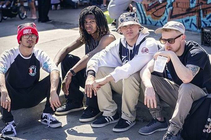 group of teenagers sitting on a sidwalk