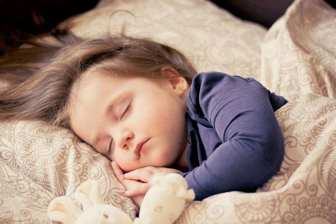 A girl sleeping with a teddy bear