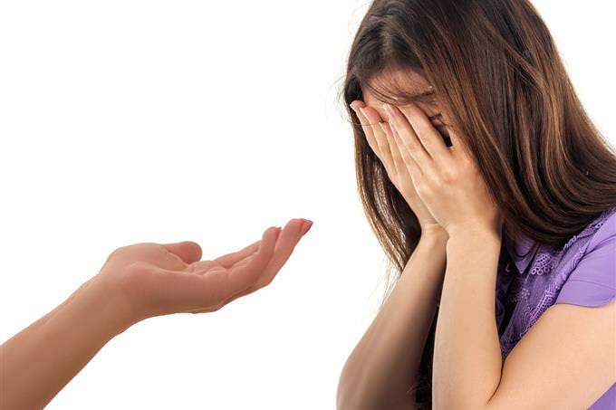 A woman crying with a hand stretched out in front of her