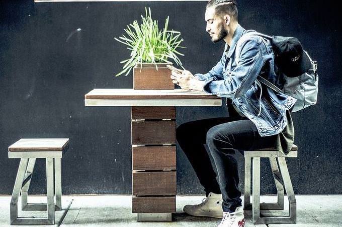 A guy sitting at a table with a bag on his back