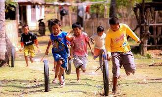 Children running in the street and rolling tires