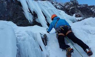 A guy climbing a snowy mountain