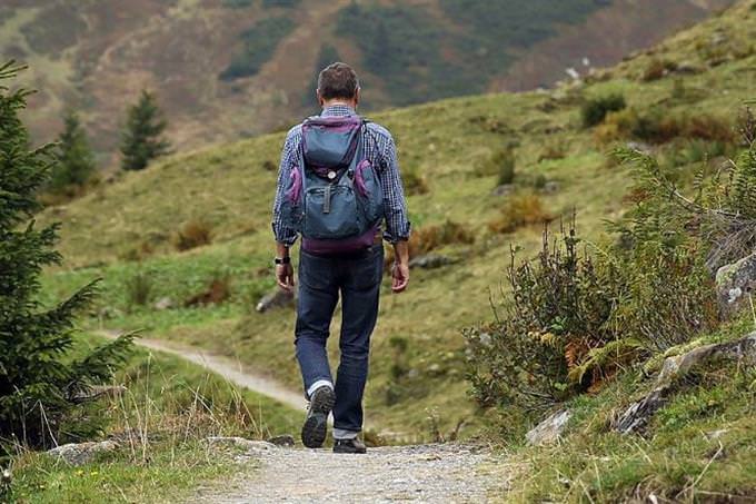 A man walking in the mountains with a knapsack on his back