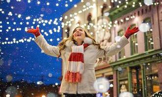 A girl in winter clothes touching snowflakes