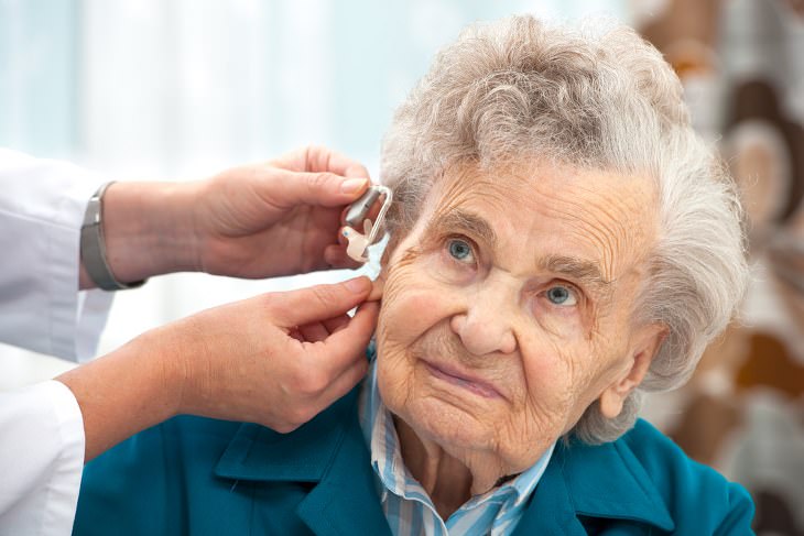 short senior jokes - old woman getting a hearing aid put on by a doctor