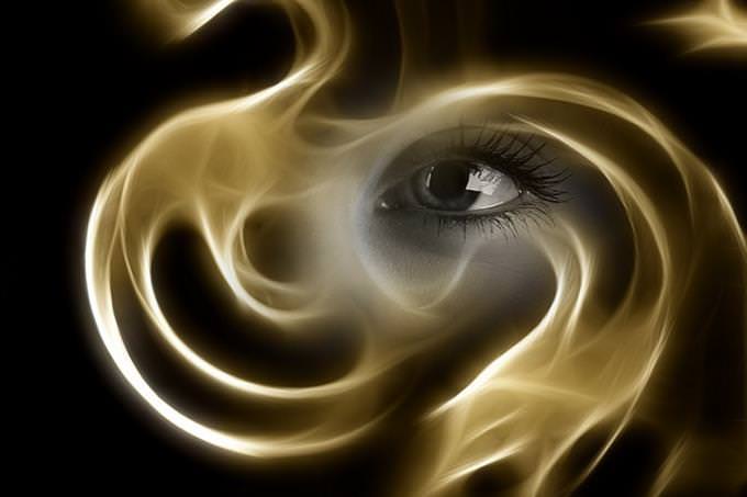 An eye behind curling smoke